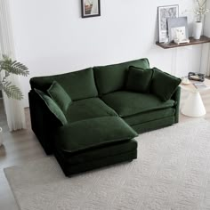 a green couch sitting on top of a white rug