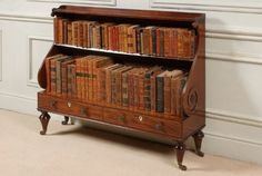 an old wooden bookcase with many books on it's sides and two drawers