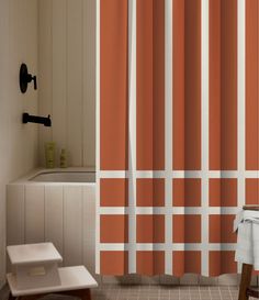 an orange and white striped shower curtain next to a bath tub with a wooden stool