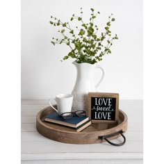 a wooden tray with two books, a vase and a coffee cup on it that says love sweet love