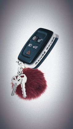 a car keychain with a red furry ball attached to it's side