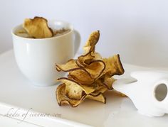 a white bowl filled with chips next to a cup