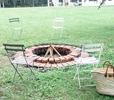 a fire pit with chairs around it and a basket on the ground next to it