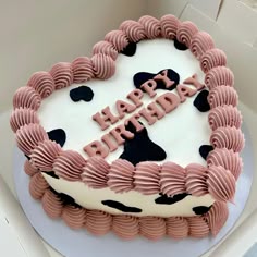 a pink and black birthday cake with the words happy birthday written in frosting on it