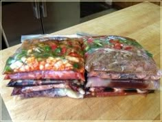 there are several bags of food on the table together, and one is wrapped in plastic