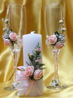 two champagne flutes with flowers and greenery on them, sitting next to each other