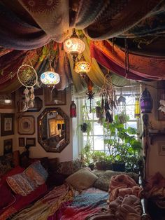 a bedroom with lots of hanging plants and pictures on the wall