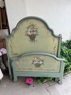 a bed with flowers painted on the headboard and foot board in front of it