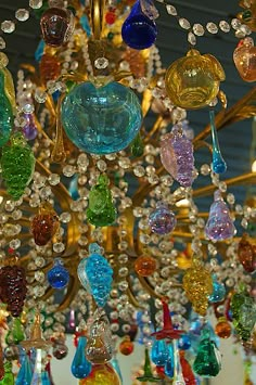 a chandelier with many different colored glass pieces hanging from it's ceiling