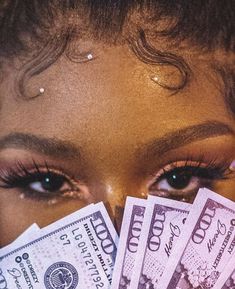 a close up of a person holding money in front of their face