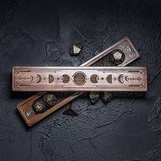 the wooden ruler is laying on top of other pieces of wood and has intricate designs