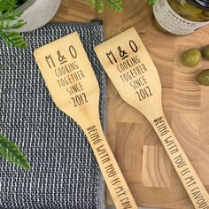 two wooden spoons sitting on top of a cutting board