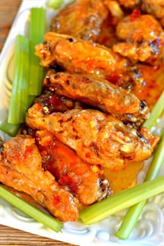 chicken wings and celery on a white plate