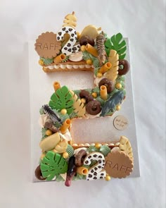 the letter e is made out of cookies and decorated with jungle animals, leaves, and flowers