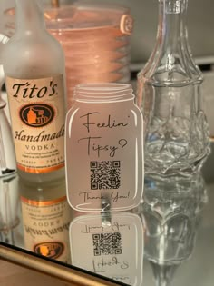 there are many bottles and glasses on the counter top, including one with a qr code