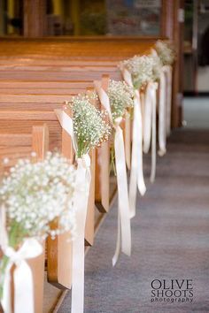 the aisle is lined with baby's breath flowers and tied in white ribbon for an elegant touch