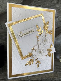 a white and gold card with flowers on it