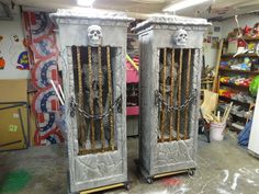 two large metal doors with chains on them in a room filled with toys and other items