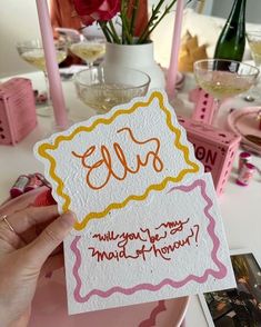 a person holding up a card with the word ell on it at a table