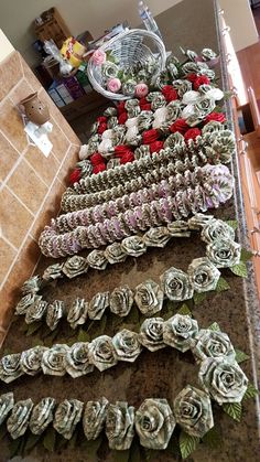 there are many different flowers on the counter top, and one is made out of rolled paper