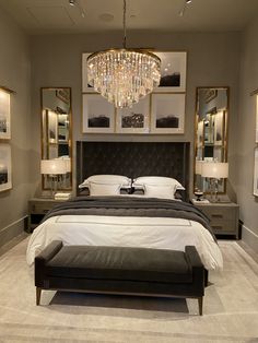 a large bed sitting in a bedroom under a chandelier