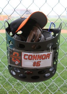 a baseball helmet hanging from a chain link fence