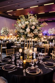 an elegant wedding reception with tall centerpieces and gold accents, candles and flowers