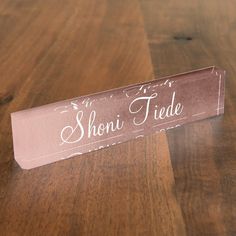 a wooden table with a sign on it that says shoni tide written in white