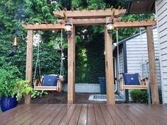 a wooden deck with swings and chairs on it