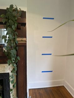 a living room with white walls and blue tape on the wall next to a fireplace