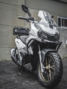 a white motorcycle parked in front of a building