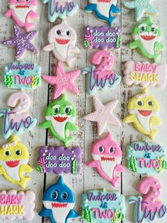 decorated cookies are arranged in the shape of shark and starfish on a wooden table