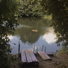 the dock is made out of wooden planks and sits in the middle of a lake