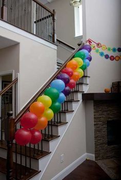 a bunch of balloons that are on the side of a stair case in a house