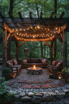 an outdoor fire pit with lights on it and some couches in the foreground