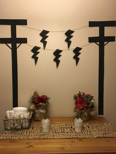 a wooden table topped with two crosses and vases filled with flowers next to each other