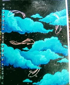 a spiral notebook with blue clouds and birds flying in the sky on it's cover