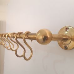 an image of a gold curtain rod with hooks on it