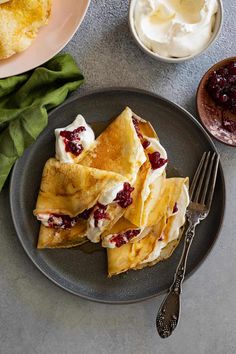 some crepes are on a plate with butter and jelly