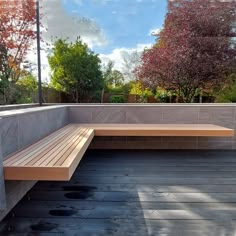 a wooden bench sitting on top of a hard wood floor next to a tree filled park