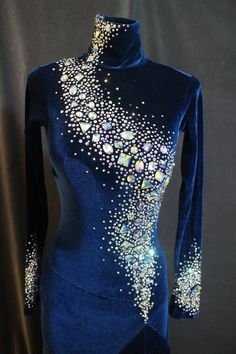 a blue dress with white and silver beads on the neck, along with long sleeves