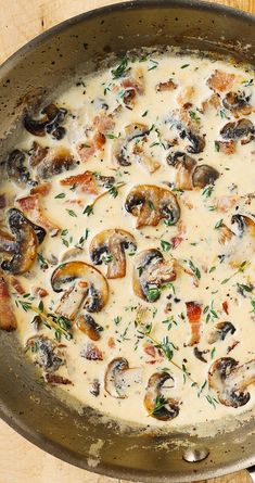 a pan filled with mushrooms and cheese on top of a wooden table