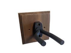 a pair of black handles are attached to a wooden wall hook on a white background