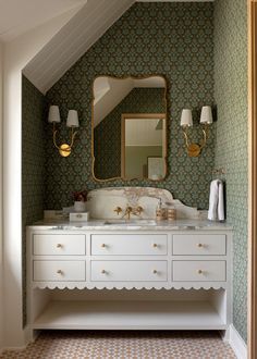 a bathroom with green and white wallpaper, two sinks and a gold framed mirror