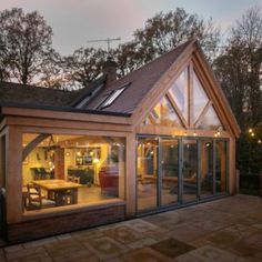 a house that is sitting in the middle of a yard with glass doors on it