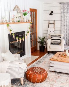 a living room with white furniture and a fireplace