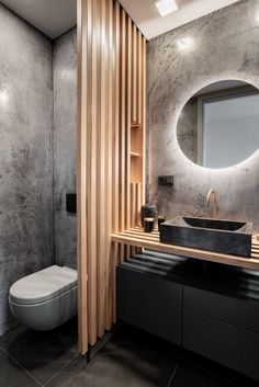 a bathroom with a toilet, sink and mirror