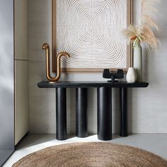 a black table with two vases and an umbrella on it in front of a white wall