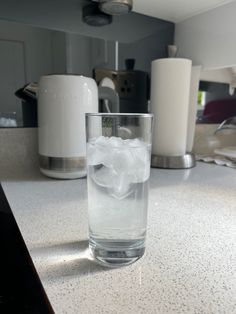 a glass filled with ice sitting on top of a counter