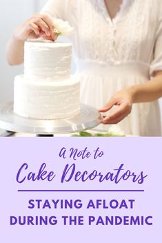 a woman is decorating a cake with white frosting and flowers on the top